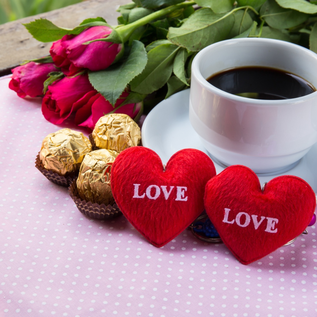 Белая чашка кофе на столе с букетом роз, конфетами и красными сердечками