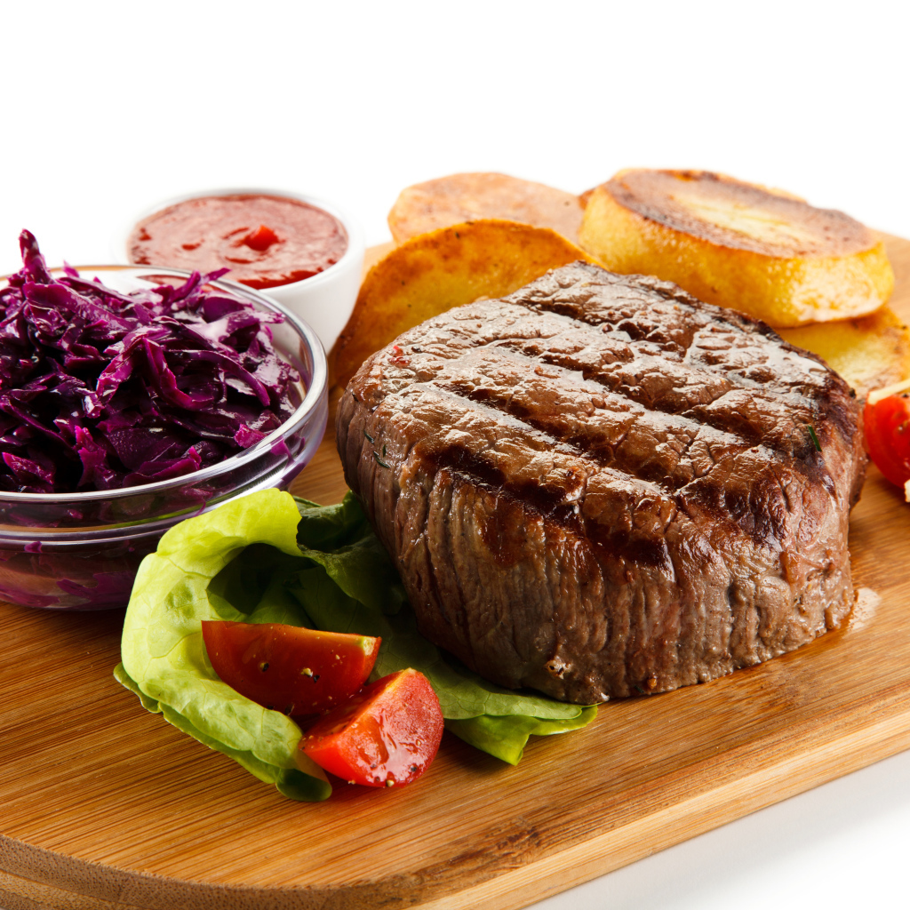 Кусок мяса гриль на доске с салатом и овощами