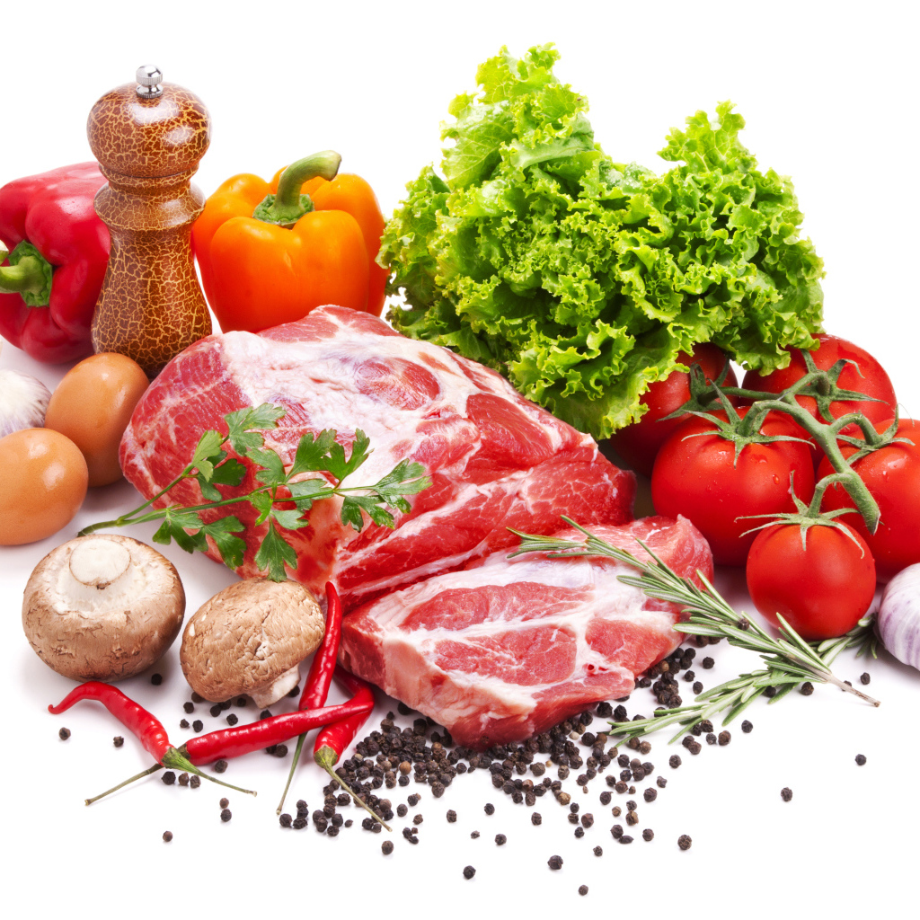 Кусок мяса на белом фоне с овощами и специями