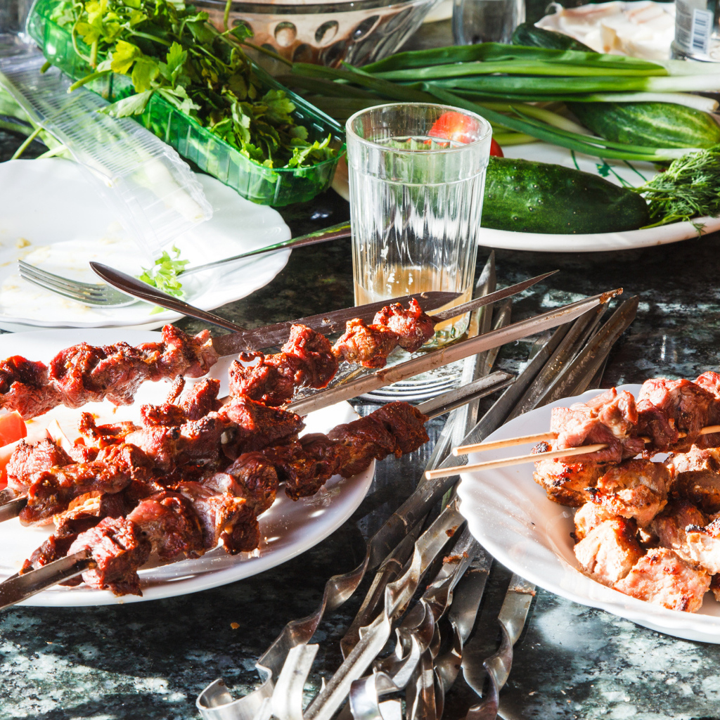 Аппетитный шашлык на шампурах на столе 