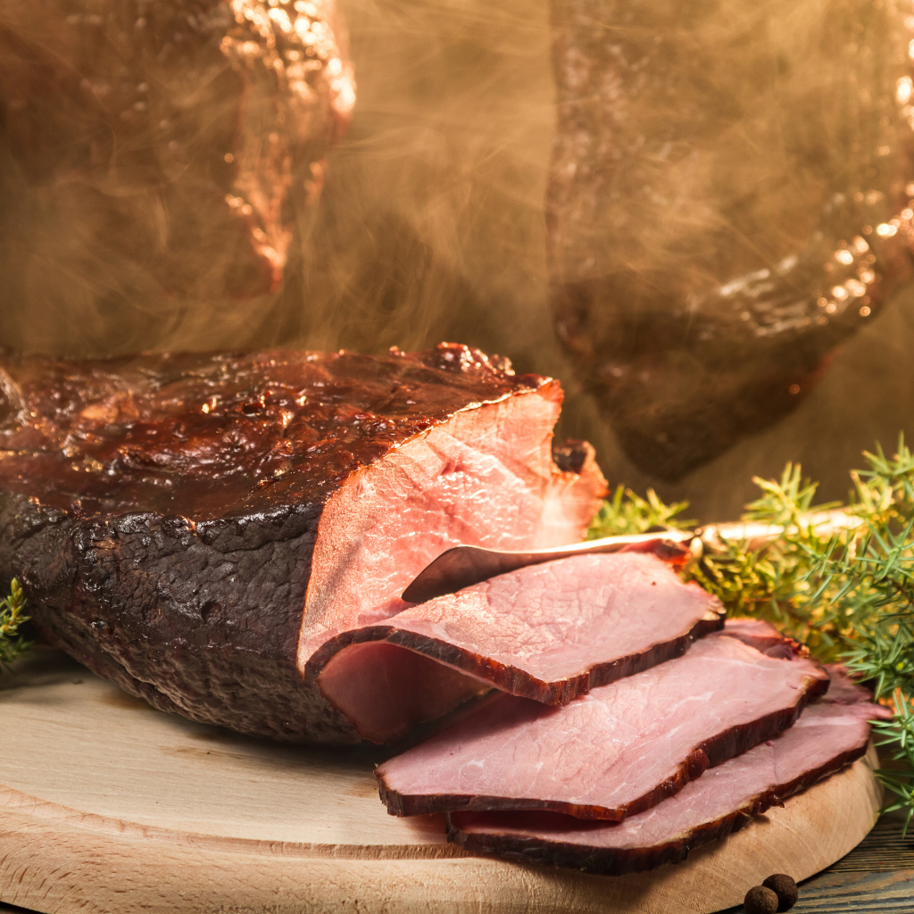 Аппетитный кусок сочной ветчины нарезан на разделочной доске