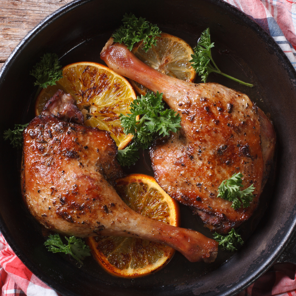 Куриные окорочка в сковороде с кольцами апельсина и петрушкой