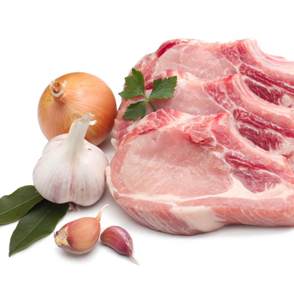 Куски мяса на белом фоне с луком и чесноком