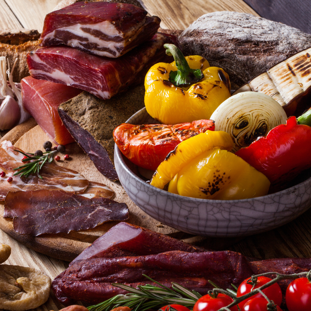 Мясные продукты на столе с запеченными овощами