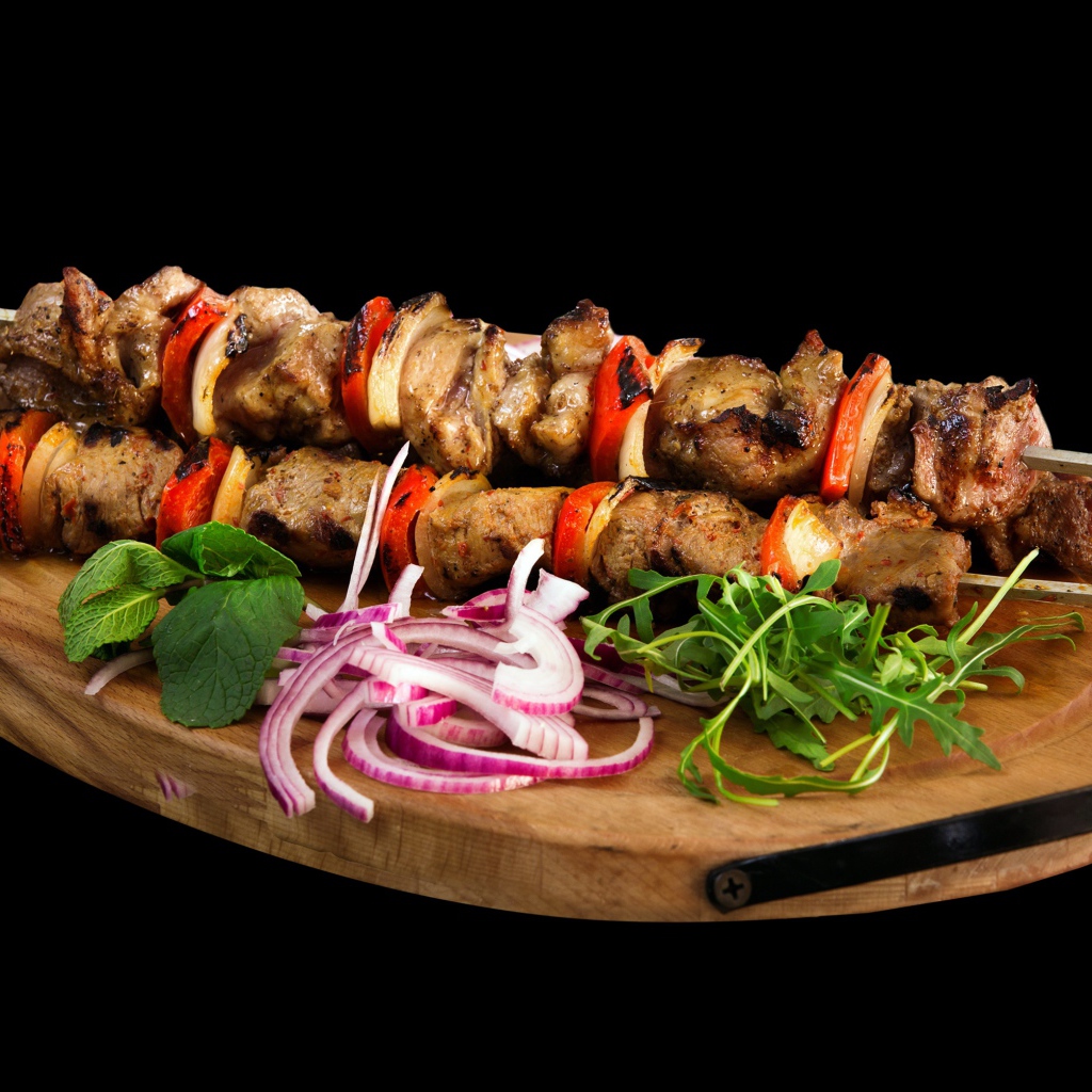 Шашлык на разделочной доске с луком и зеленью 