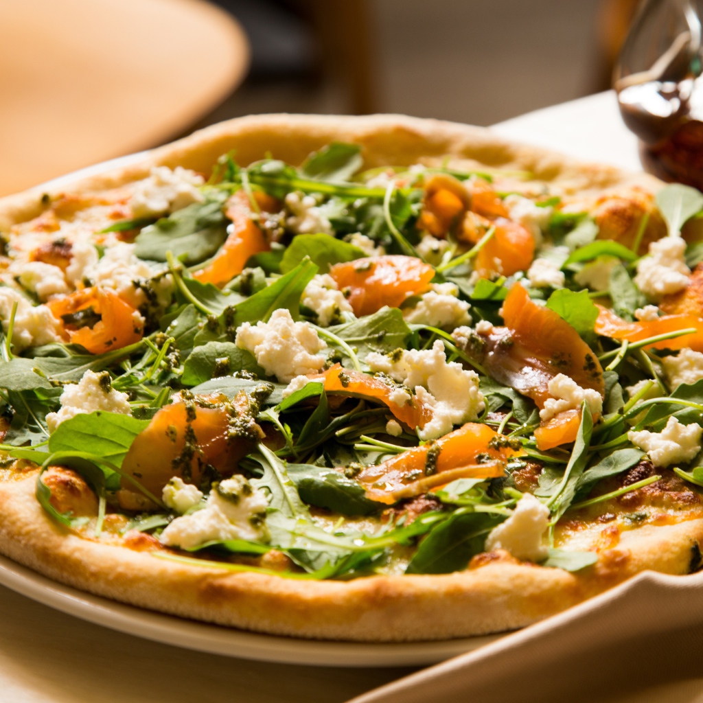 Аппетитная пицца с рыбой и зеленью на столе