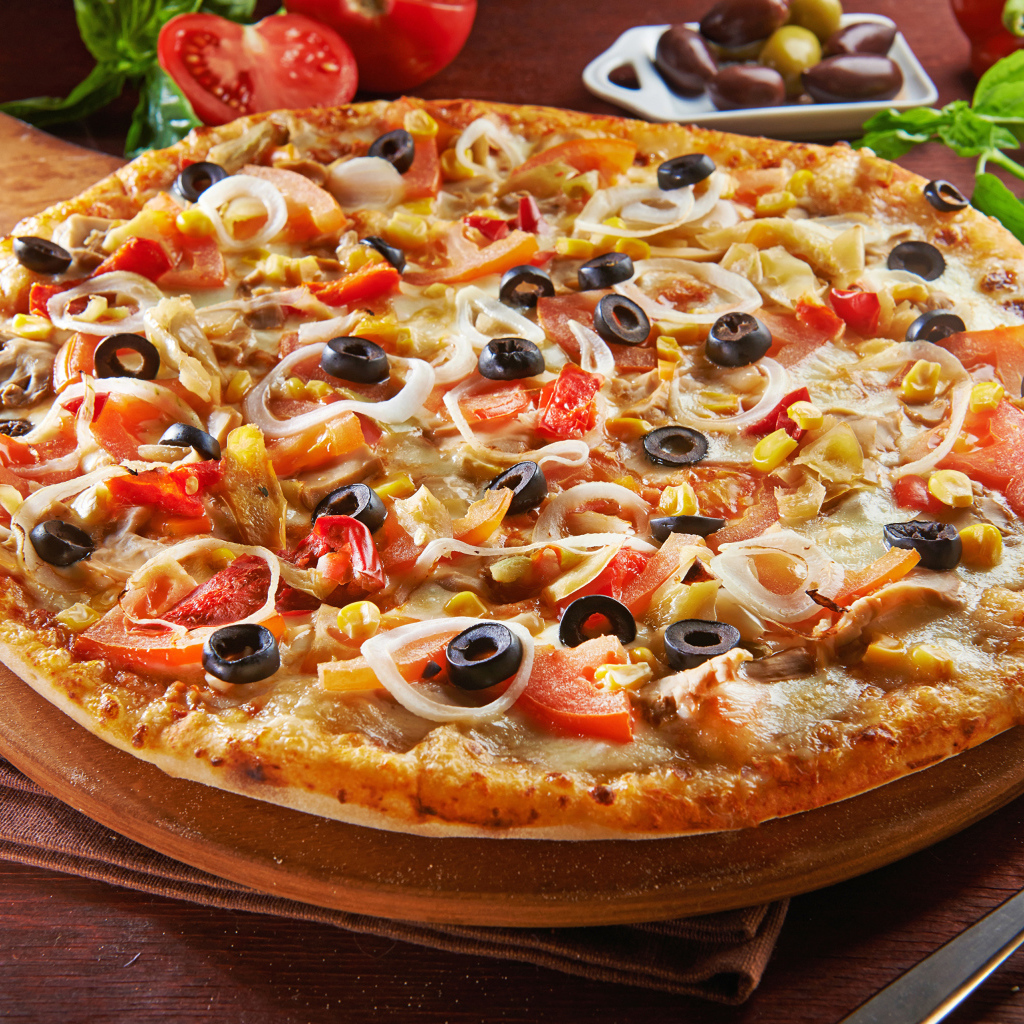 Большая пицца на доске с оливками и помидорами