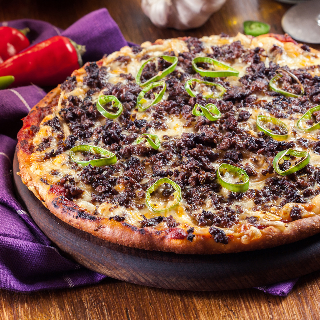 Пицца на доске с мясом и перцем 