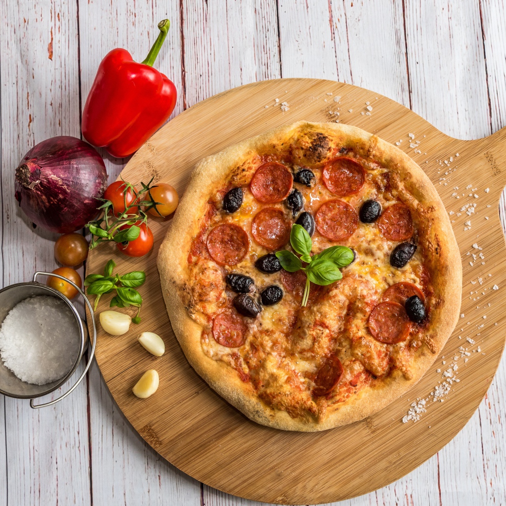 Пицца на доске с овощами и солью 