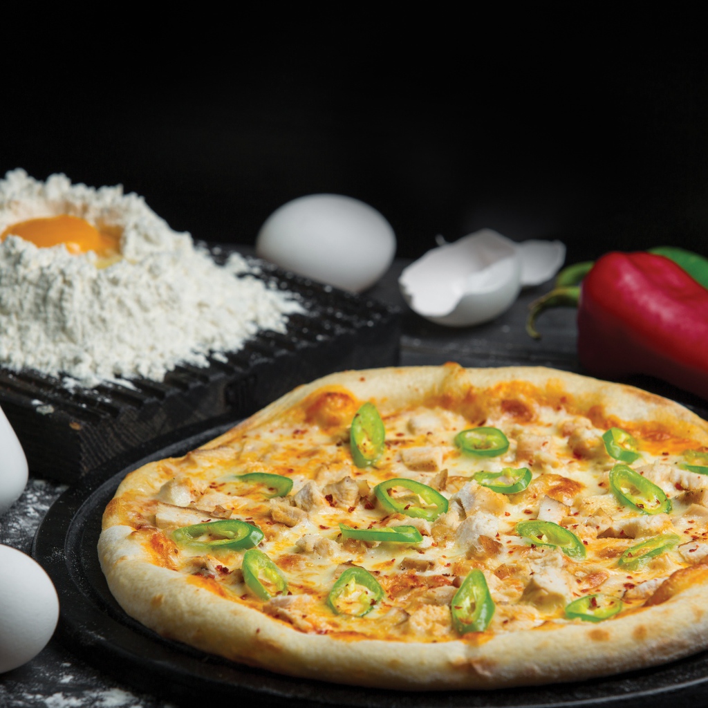 Пицца на столе с яйцами и перцем