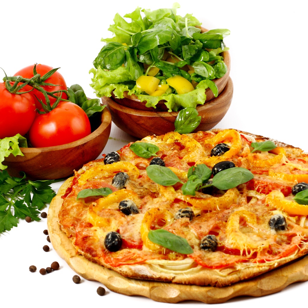 Пицца на столе с овощами и зеленью на белом фоне