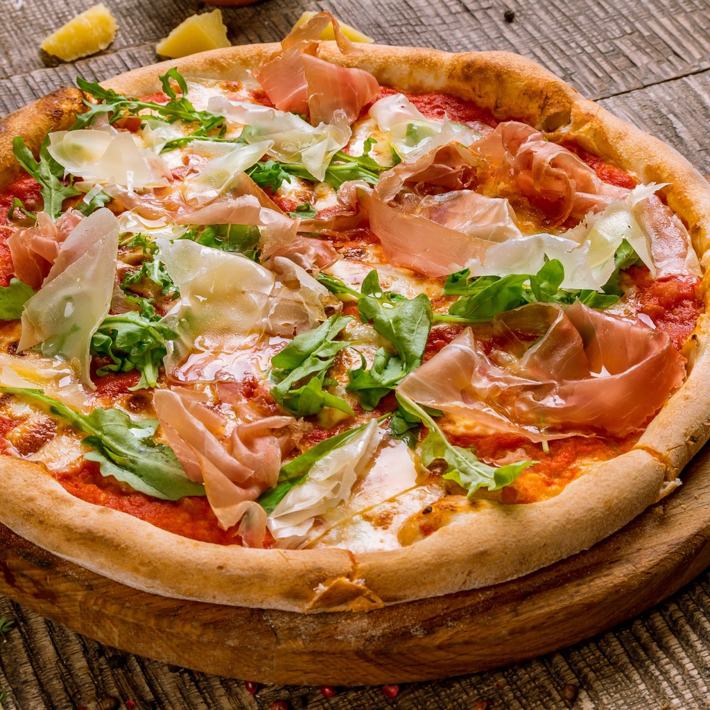 Пицца с рыбой и рукколой  на разделочной доске 