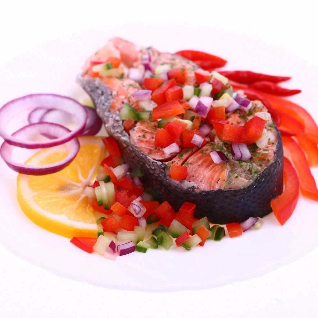 Кусок красной рыбы с овощами на белом фоне