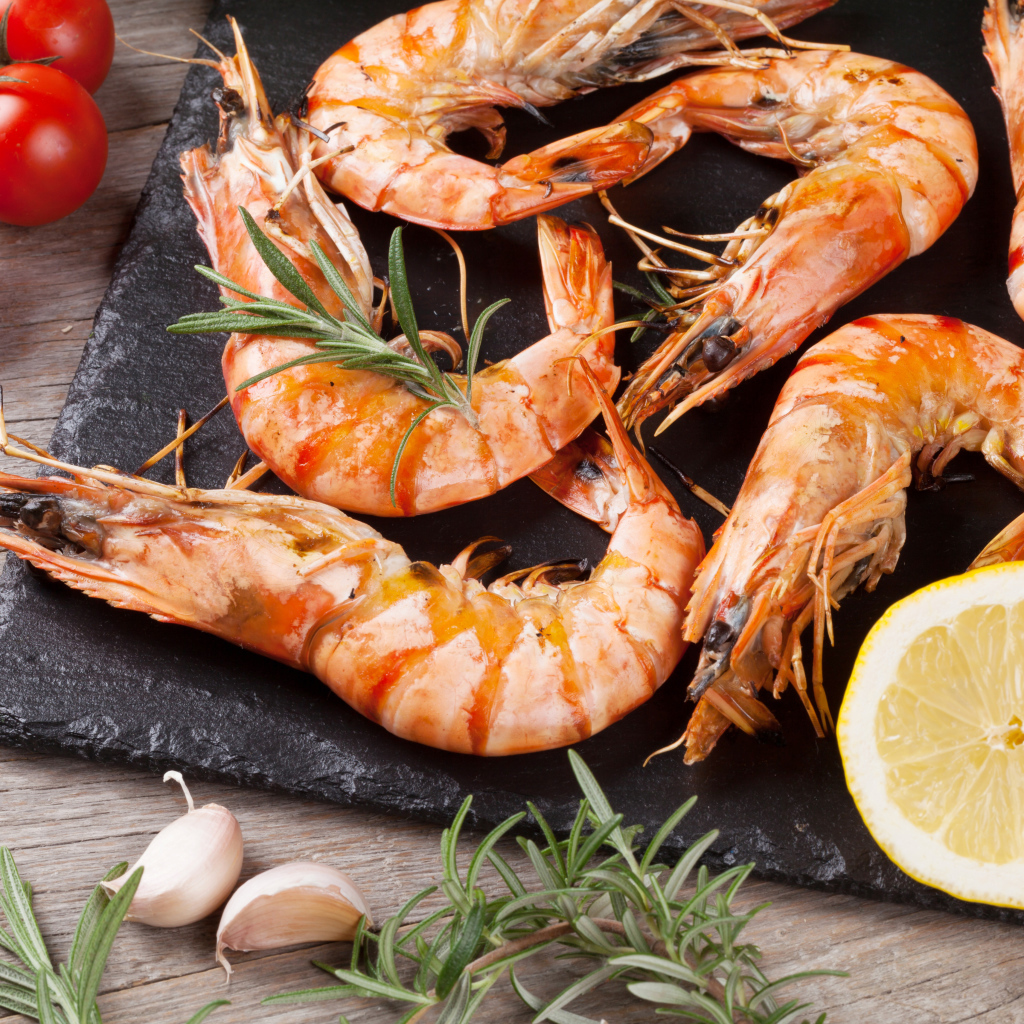 Boiled shrimps on the table with lemons and tomatoes
