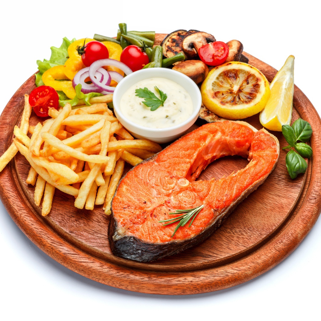 Рыба на доске с картофелем фри, овощами и соусом