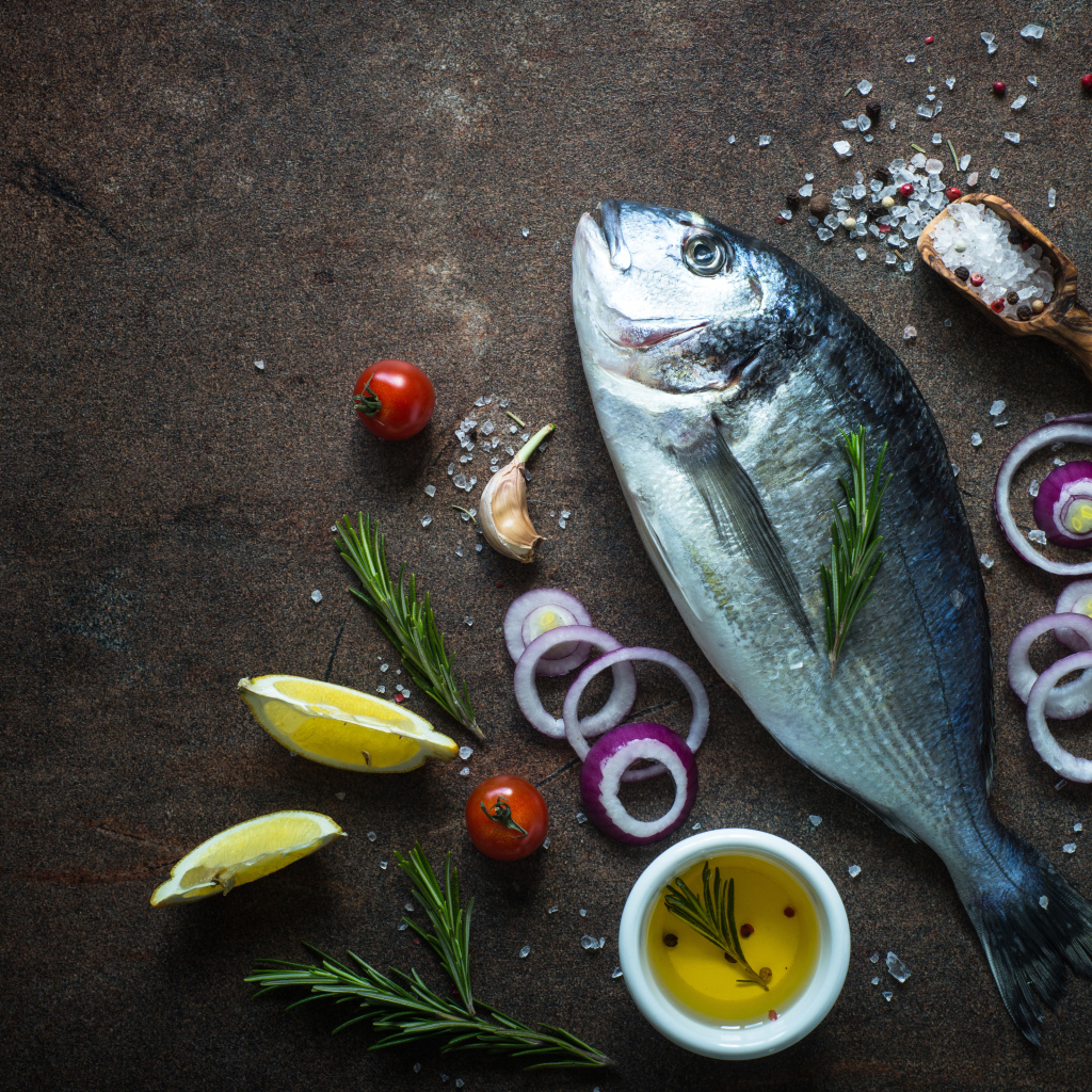 Свежая рыба на столе с овощами и специями 