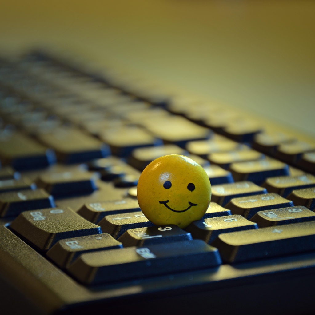 Желтый смайлик на черной клавиатуре 