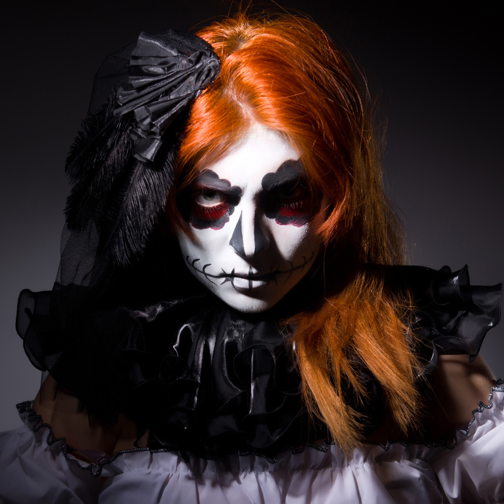 Рыжеволосая девушка с маской на лице на Хэллоуин 