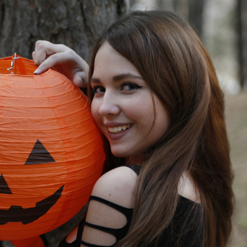 Улыбающаяся девушка с декором на праздник Хэллоуин
