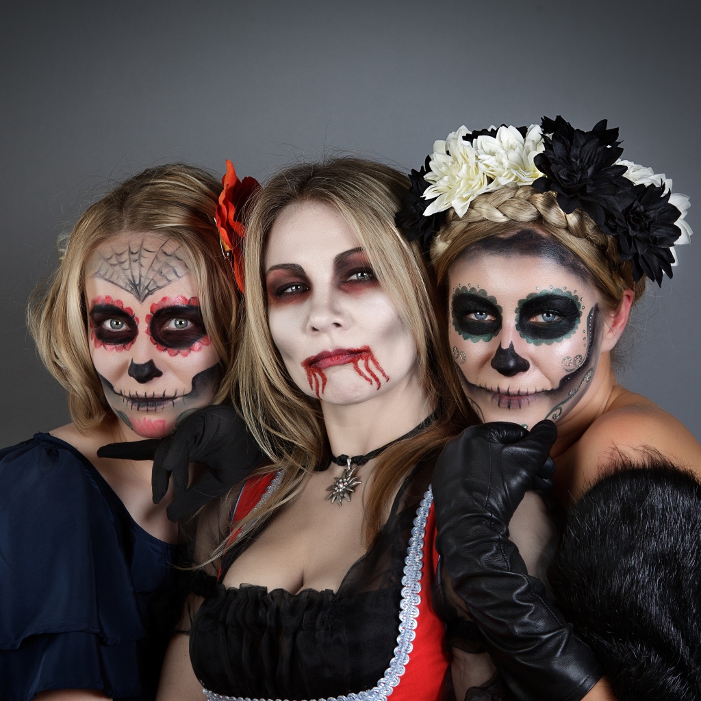 Три девушки с масками и в костюмах на Хэллоуин 