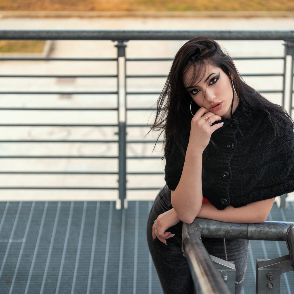 Красивая девушка стоит на ступеньках у перил 