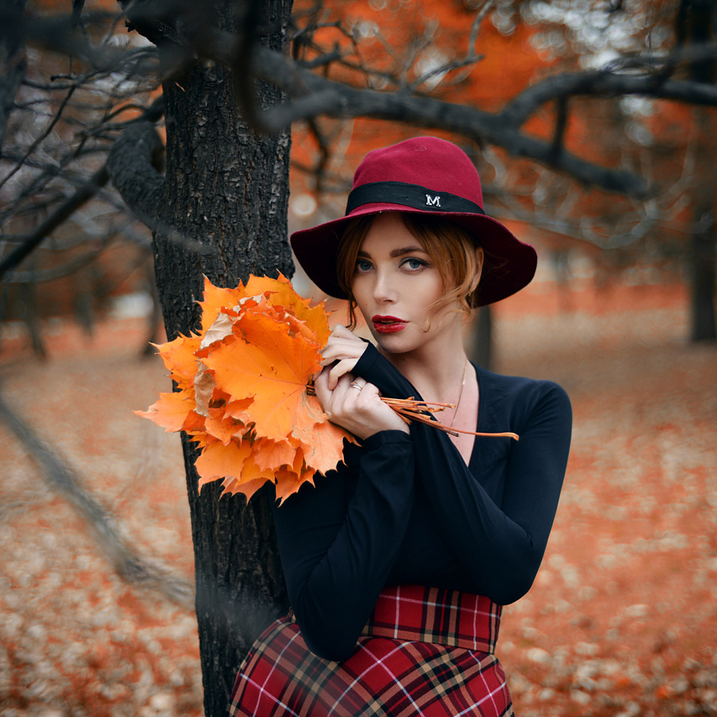 Девушка стоит у дереве с желтыми листьями осенью
