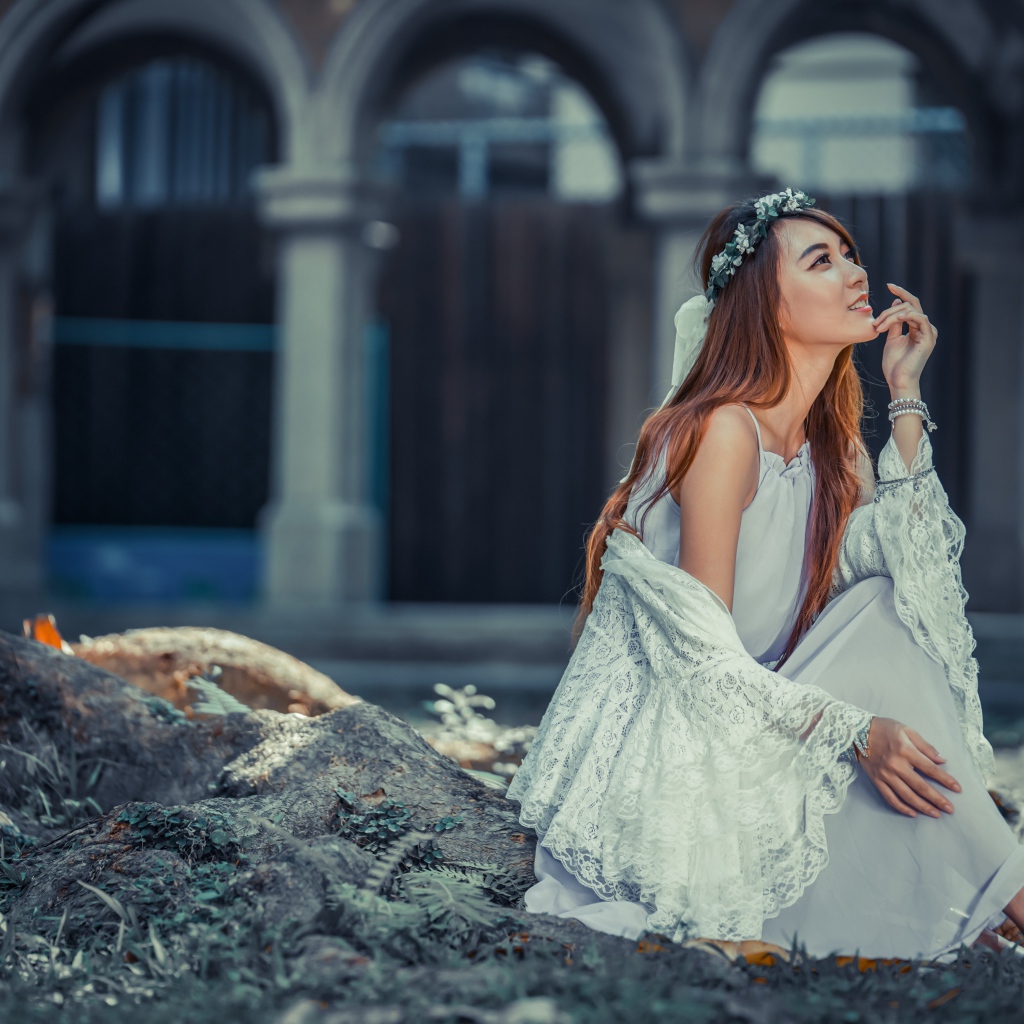 Мечтательная девушка азиатка в белом платье