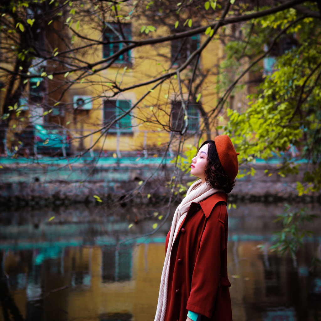 Девушка азиатка в красном пальто у воды