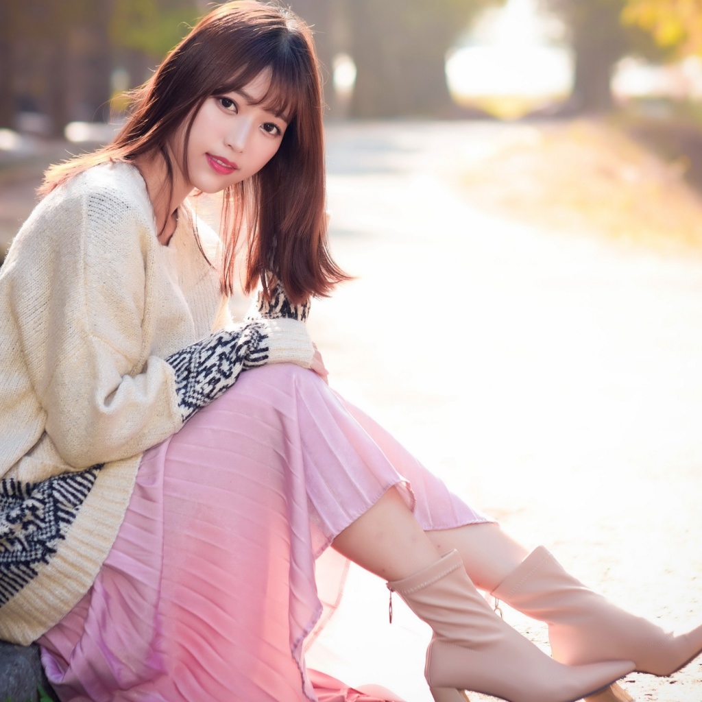 Девушка азиатка сидит на земле 