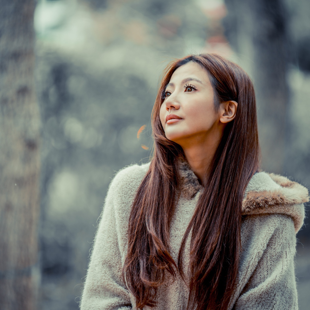 Длинноволосая девушка азиатка смотрит в сторону