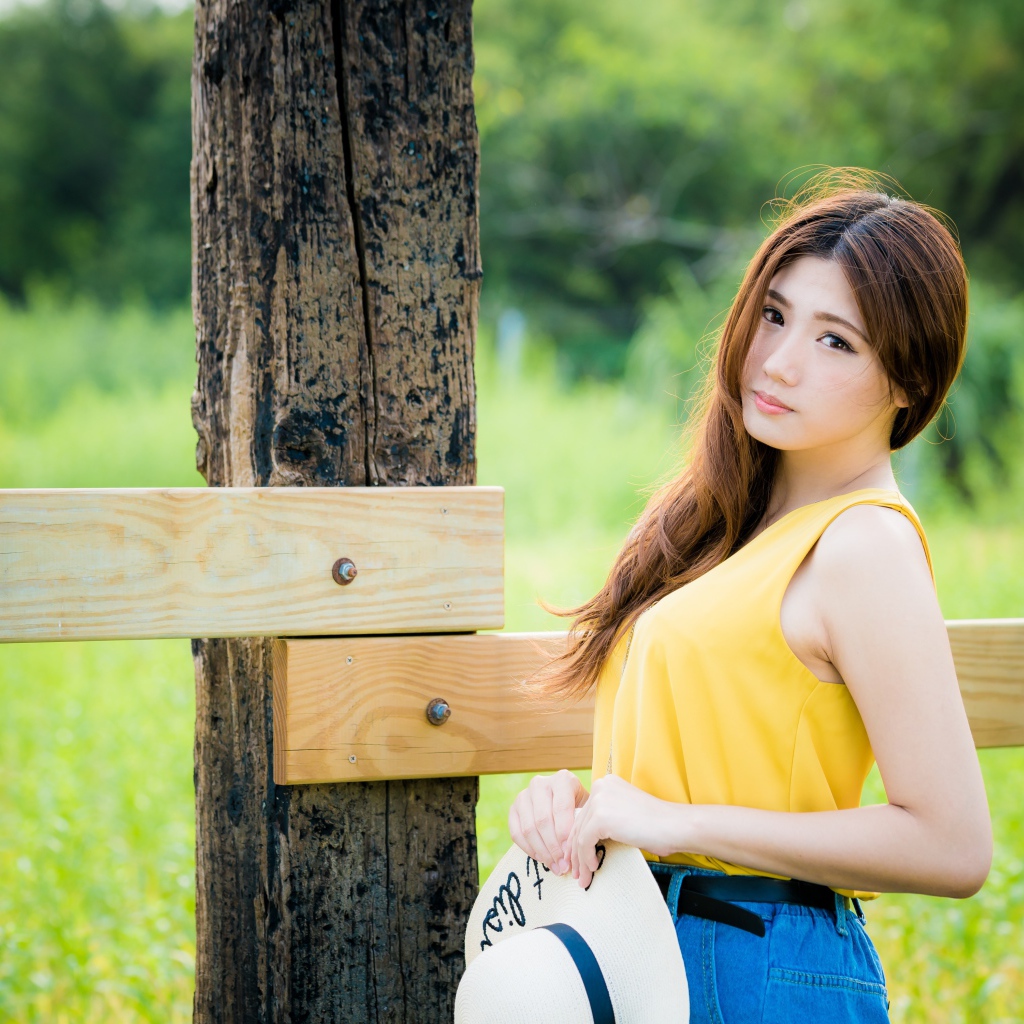 Красивая азиатка у деревянного столба 