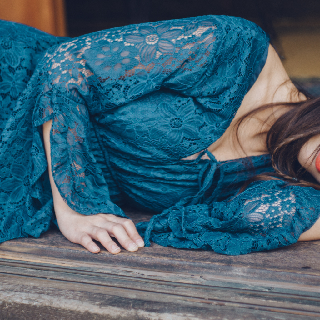 Красивая девушка азиатка в платье лежит на полу