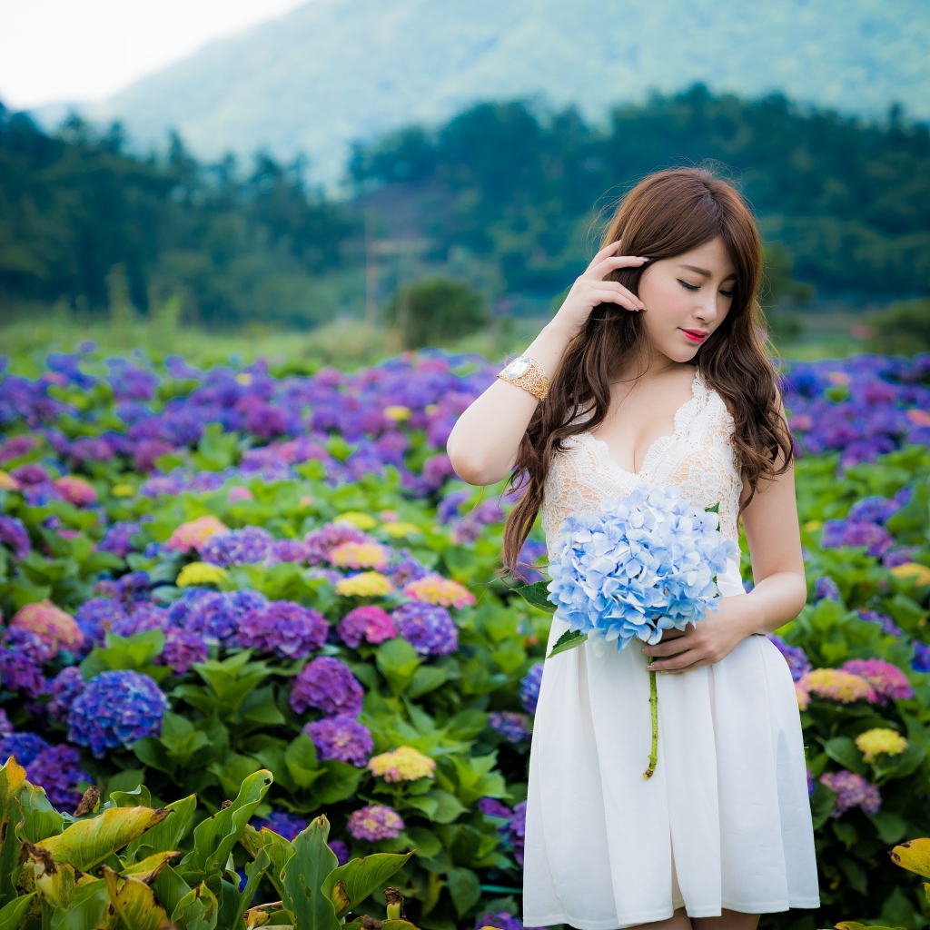 Красивая девушка азиатка в белом платье с цветами гортензии 