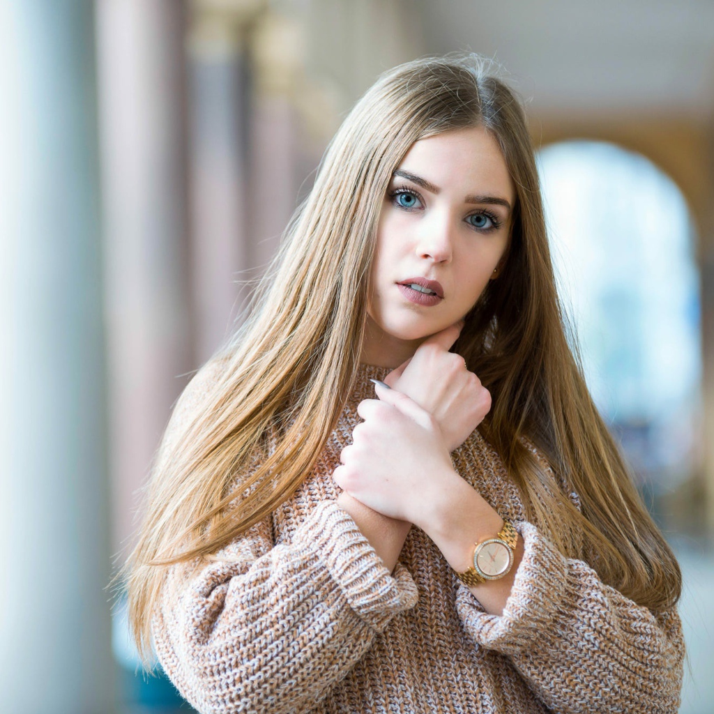 Красивая голубоглазая блондинка в теплом свитере с часами на руке