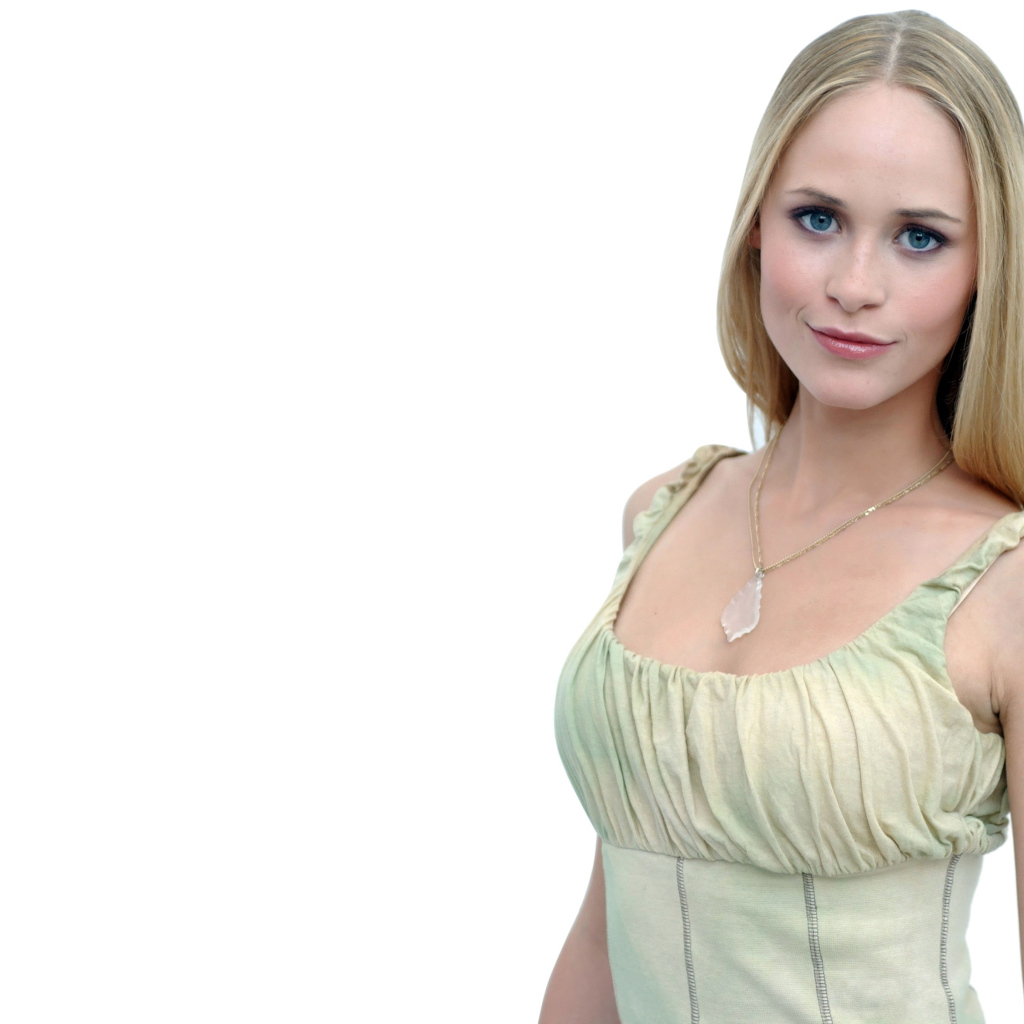 Красивая голубоглазая блондинка на белом фоне с кулоном на шее 