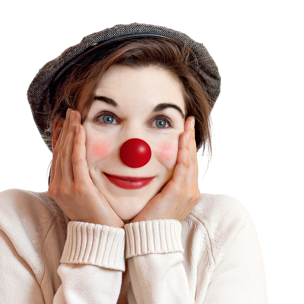 Красивая голубоглазая девушка в кепке с носом клоуна на белом фоне