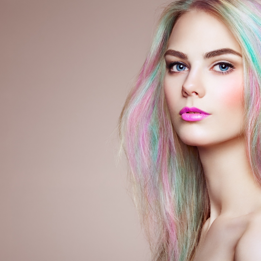 Красивая голубоглазая девушка с разноцветными волосами на сером фоне