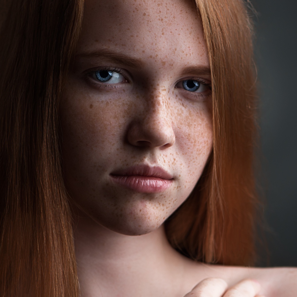 Красивая голубоглазая рыжеволосая девушка с веснушками