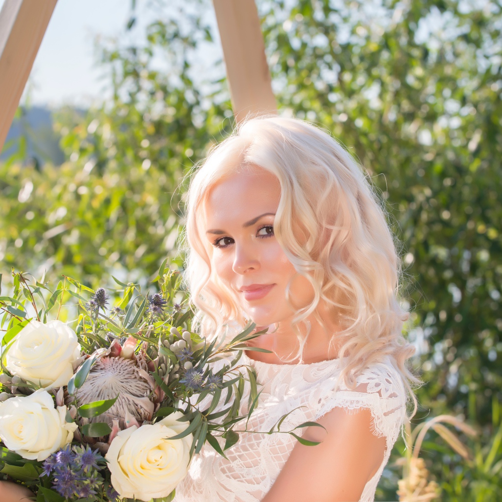 Красивая кареглазая блондинка с букетом в руках 
