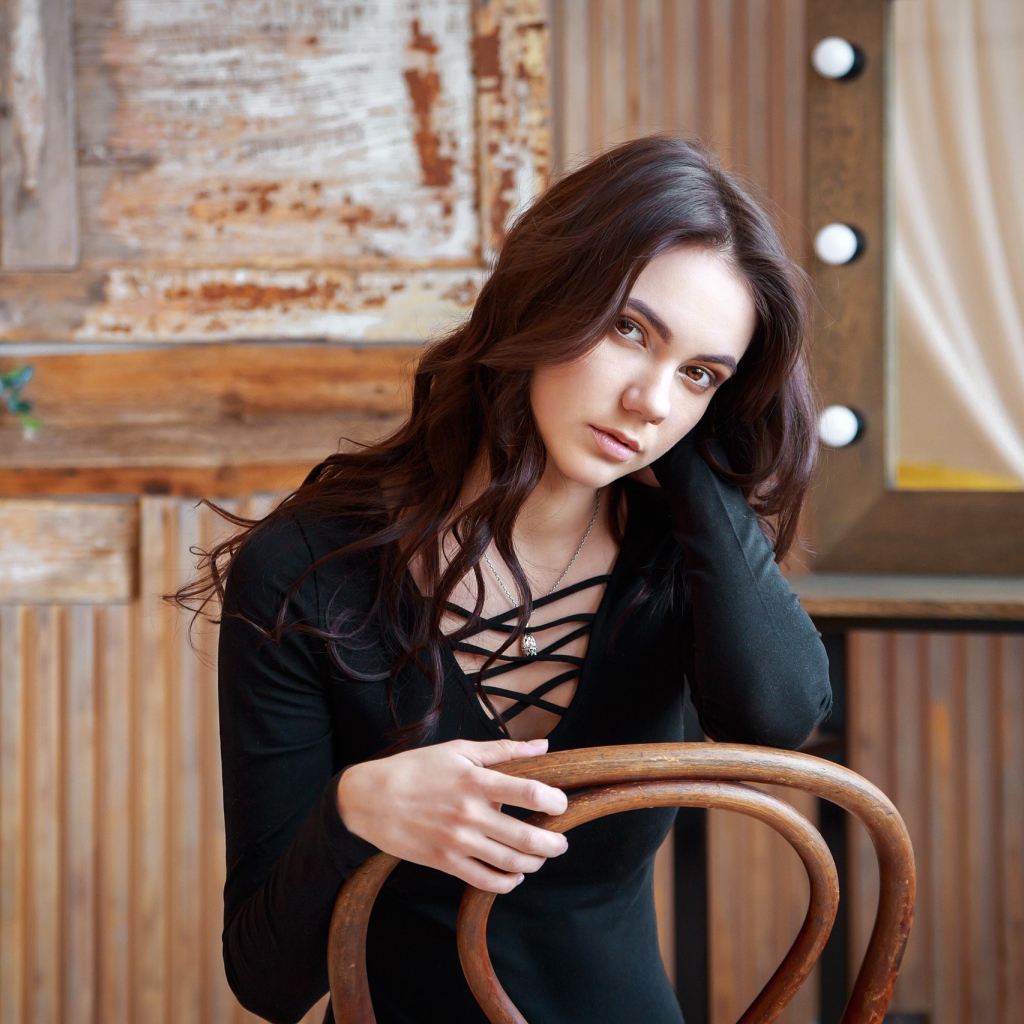 Красивая кареглазая девушка сидит на стуле