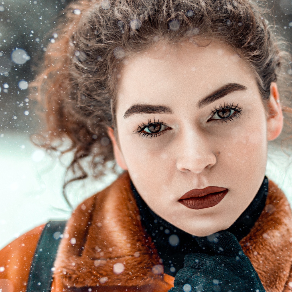 Красивая кареглазая девушка стоит на улице зимой