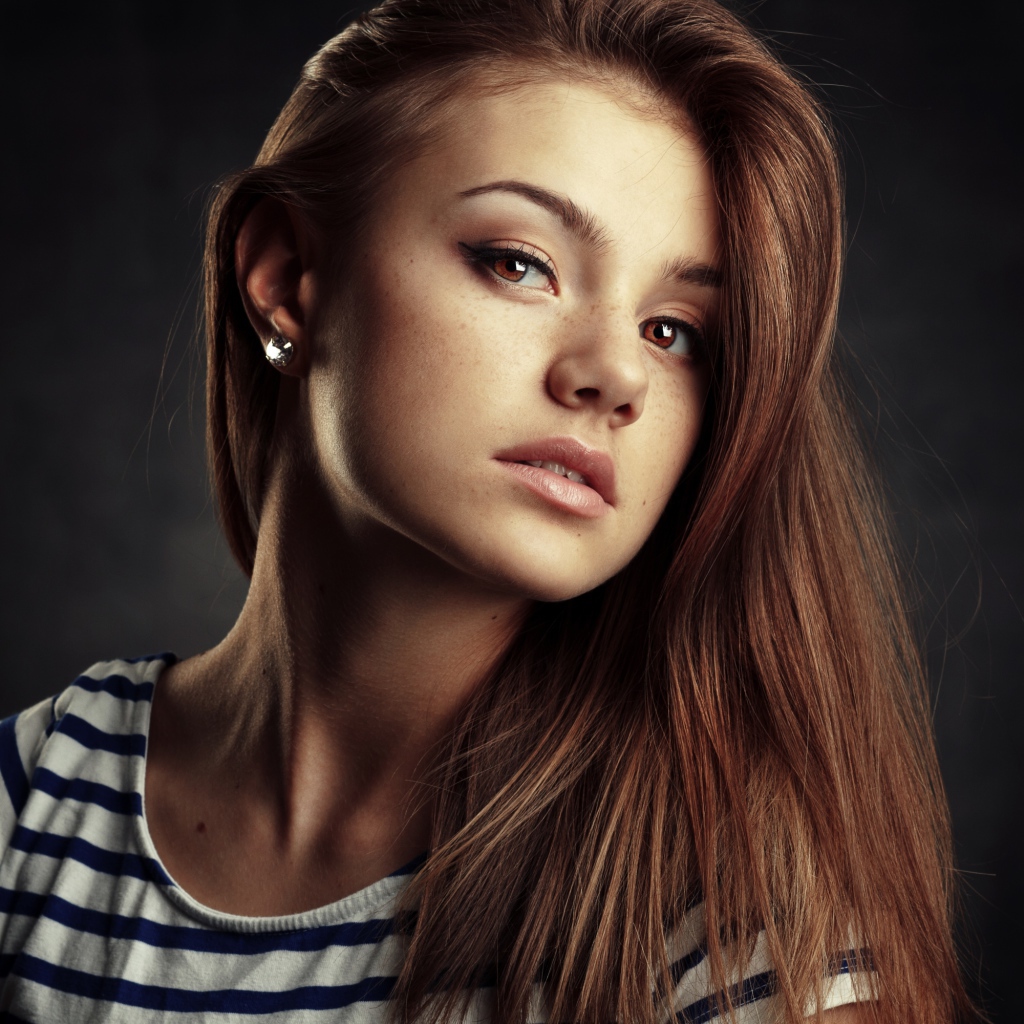 Красивая кареглазая девушка с русыми волосами на сером фоне