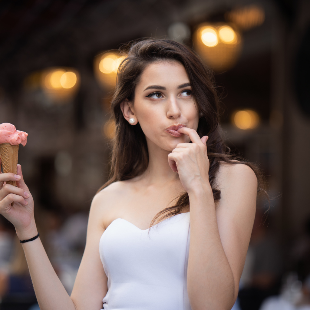 Красивая девушка шатенка с мороженым в руке