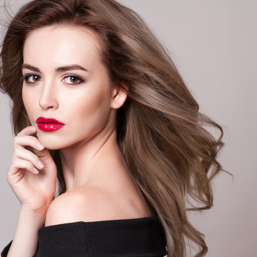 Красивая шатенка с красными губами на сером фоне