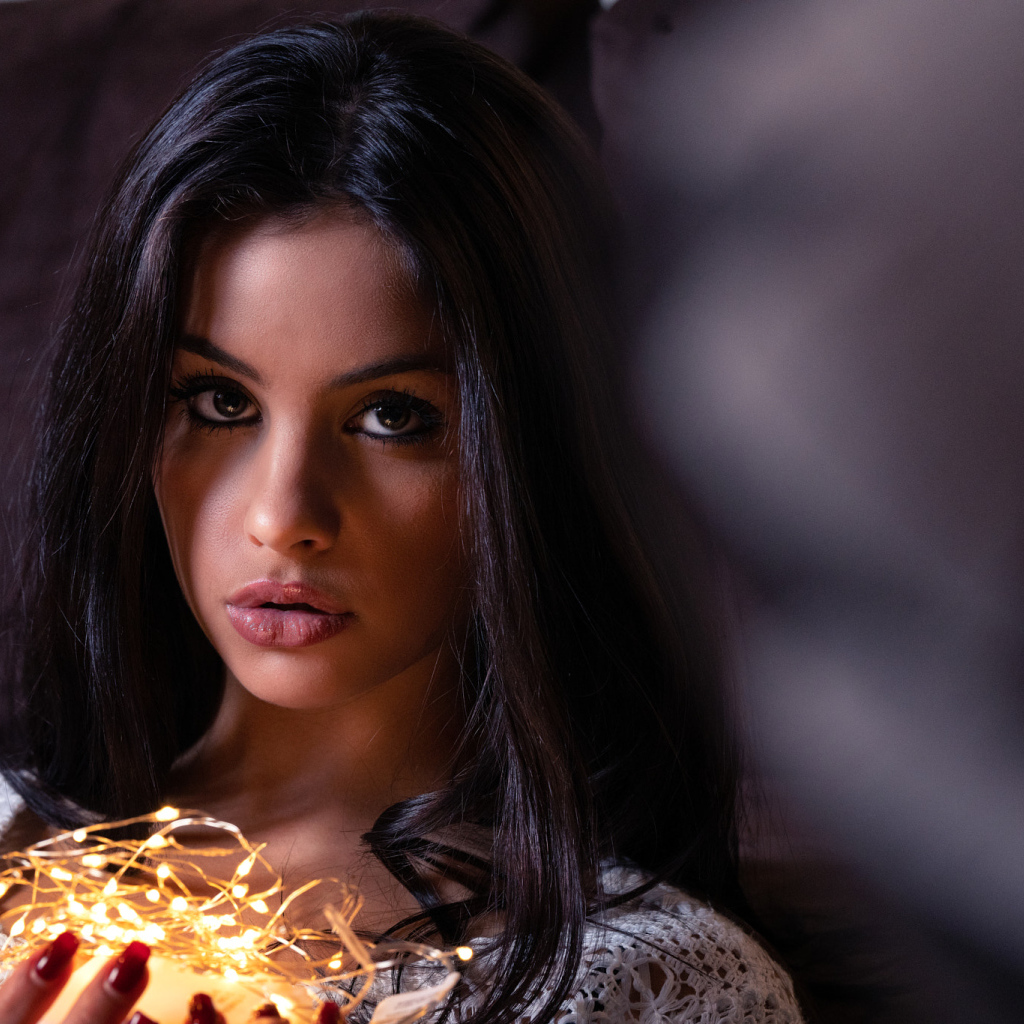 Красивая брюнетка с гирляндой в руках