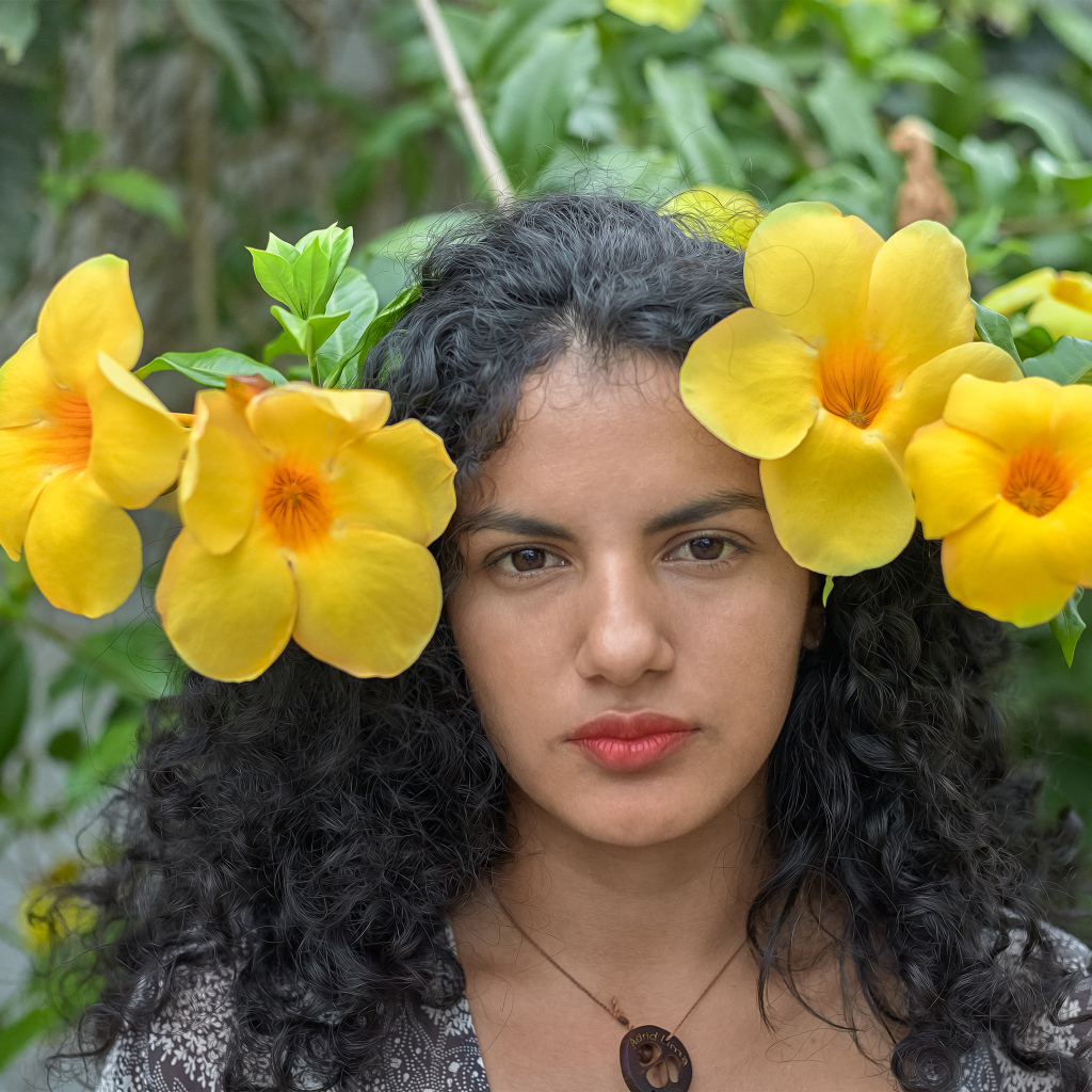 Красивая брюнетка с большими желтыми цветами в волосах 
