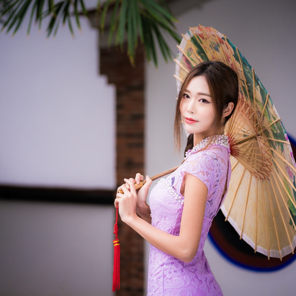 Красивая нежная азиатка в сиреневом платье с зонтом в руках