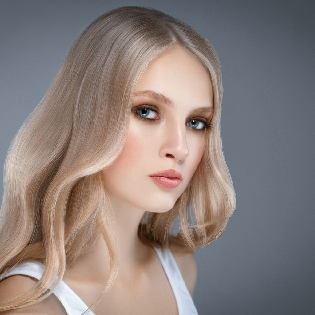 Красивая нежная голубоглазая блондинка на сером фоне
