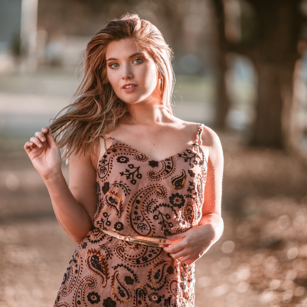 Красивая девушка в платье в лучах солнца летом