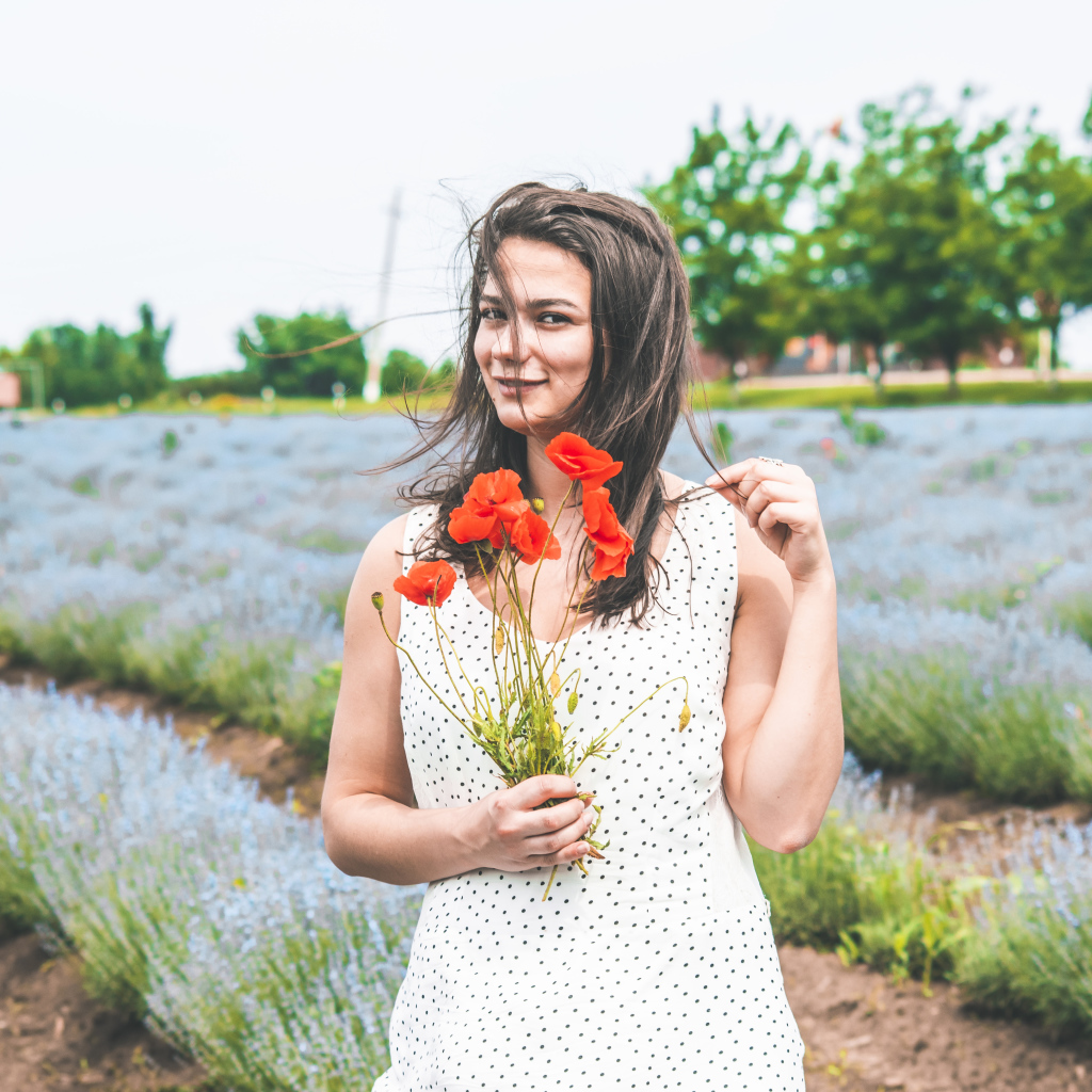 Красивая девушка в платье с букетом маков